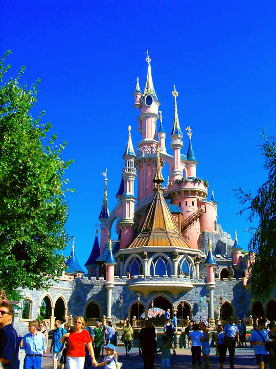 Vibrant view of Sleeping Beauty Castle on a sunny day at Disneyland Paris, a popular tourist attraction.