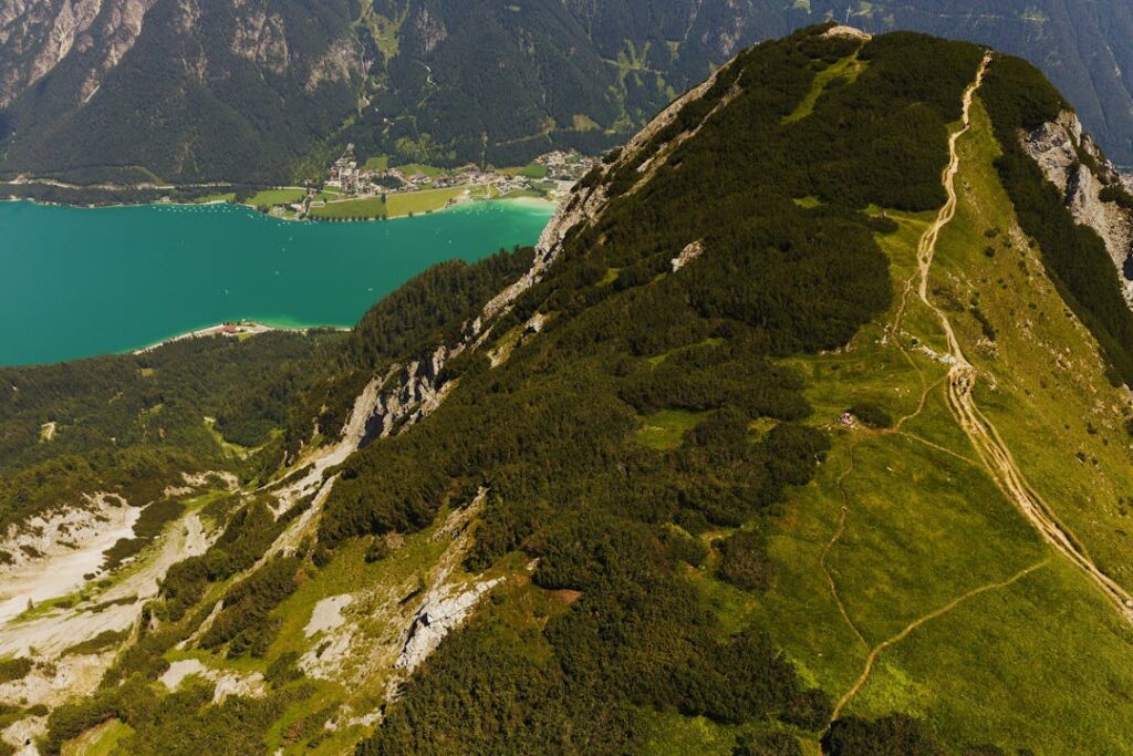 A breathtaking aerial shot showcasing the mountains and turquoise lake in Jenbach, Tyrol, Austria.