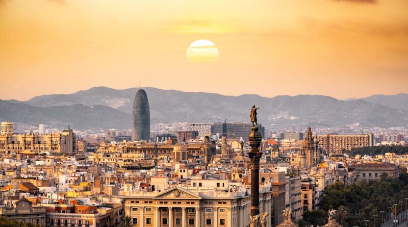 A stunning sunset view of the Barcelona skyline showcasing iconic landmarks and a warm, golden hour glow.