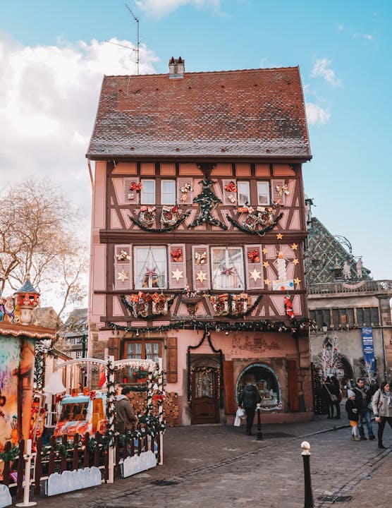 Beautifully decorated half-timbered house in Colmar, France, adorned with Christmas decorations.