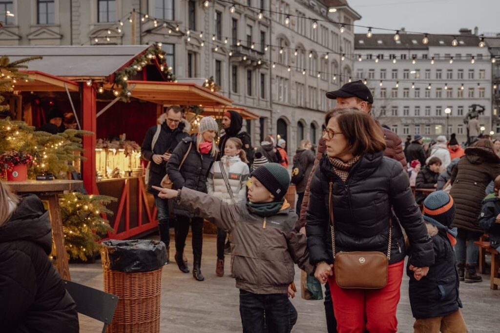 Family strolls through a festive Christmas market in Zürich, capturing the joy of the winter holidays.
