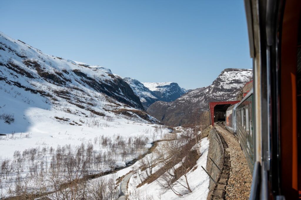 Experience an unforgettable train ride through snow-covered landscapes and majestic fjords in Flåm, Norway.