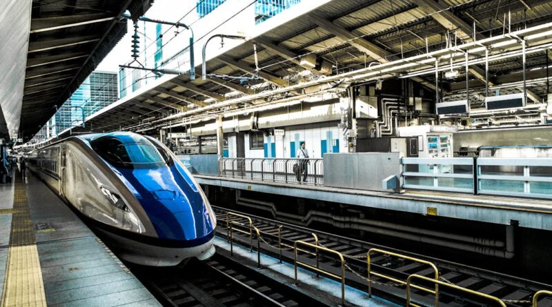 Sleek bullet train at a busy city station, epitomizing speed and modern transportation.