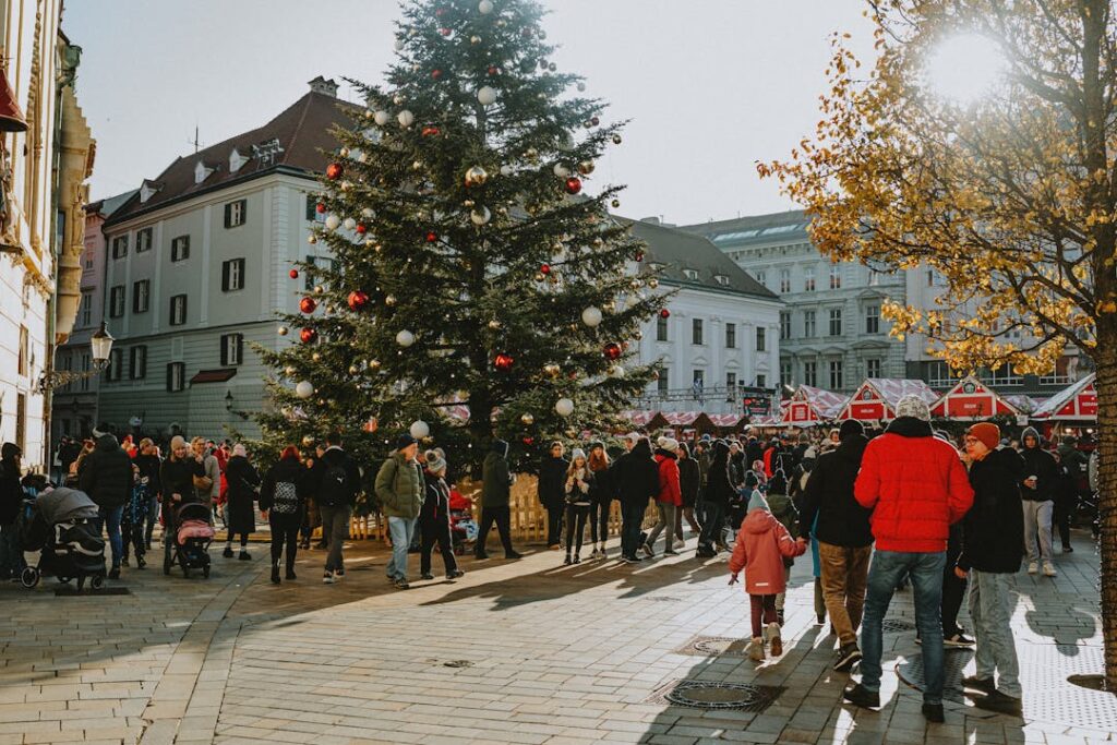 A bustling Christmas market with a large decorated tree and people enjoying the winter festivities.