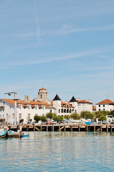 A scenic waterfront view of Ciboure, France, featuring historic architecture under a blue sky.