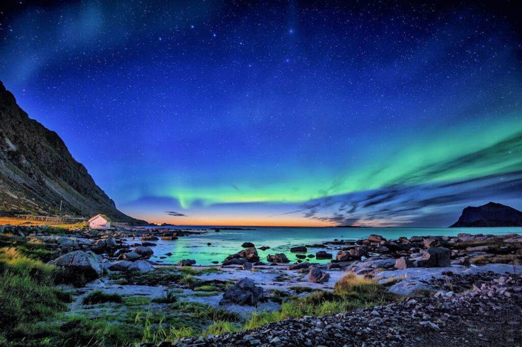 Stunning Northern Lights display over a coastal landscape during night.