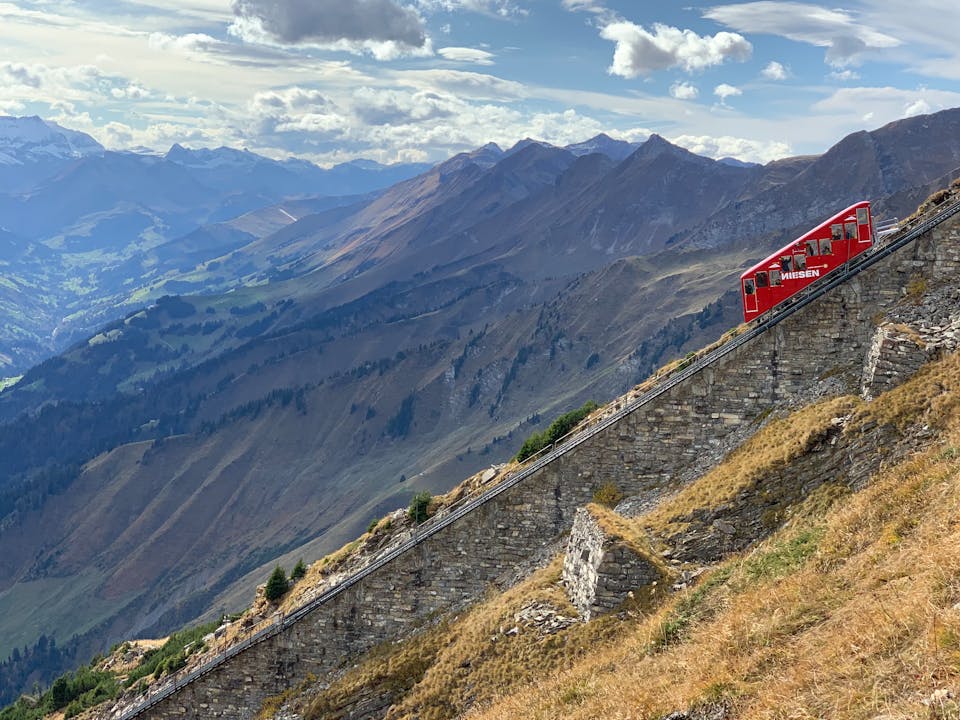 Breathtaking view of the Niesen funicular scaling the steep Swiss Alps under a bright sky.