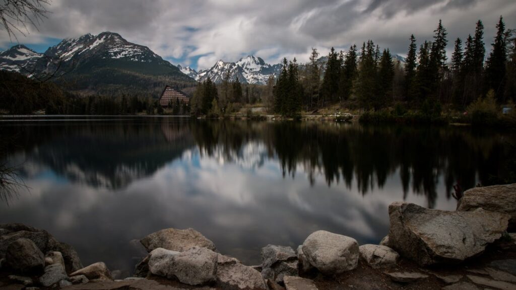 Mountain reflection in lake, scenic High Tatras, Slovakia landscape captured at dusk.
