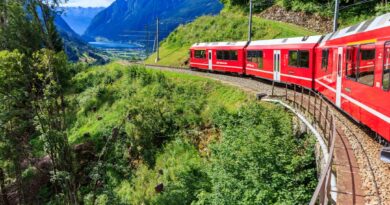 Bernina Express train curves through the stunning Swiss Alps, offering breathtaking views of mountains and valleys.
