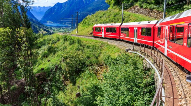 Bernina Express train curves through the stunning Swiss Alps, offering breathtaking views of mountains and valleys.