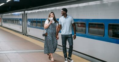 A happy couple walking hand in hand along a train platform, exuding joy and connection.