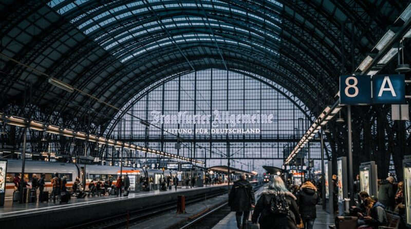 Interior view of Frankfurt Hauptbahnhof with trains and commuters.